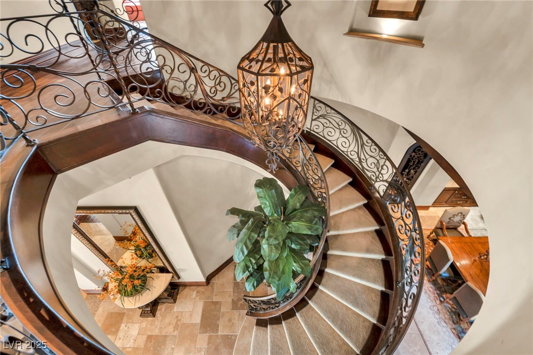 1793 Anelli Court Henderson, NV 89012 - Photo 33 of 47 Stairway with a chandelier and stone finish floors