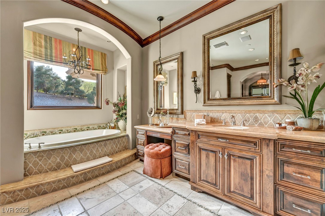 1793 Anelli Court Henderson, NV 89012 - Photo 42 of 47 Full bathroom with ornamental molding, vanity, a garden tub, stone tile floors, and backsplash