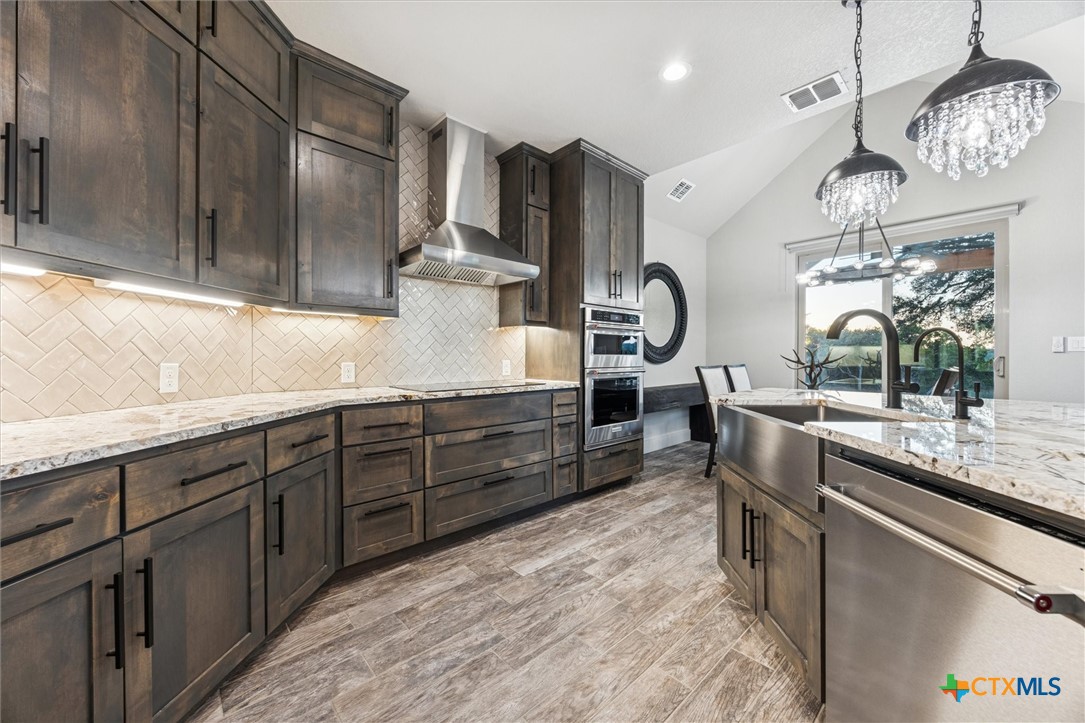 134 Flanders Fischer, TX 78623 - Photo 14 of 37 a kitchen with stainless steel appliances kitchen island granite countertop a sink and cabinets