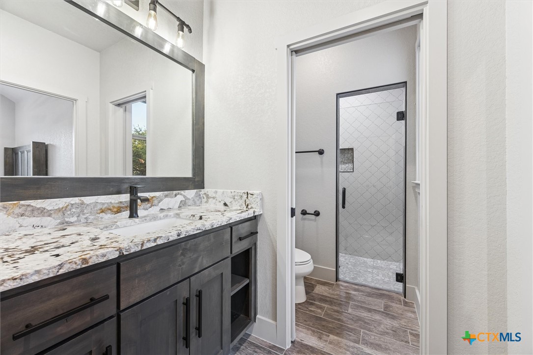 134 Flanders Fischer, TX 78623 - Photo 26 of 37 a bathroom with a granite countertop sink toilet and shower