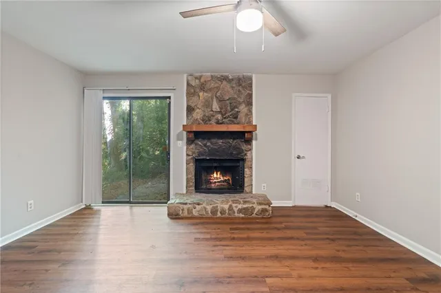 a view of a livingroom with wooden floor a fireplace and window