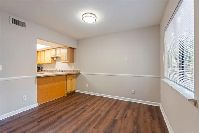 a view of a kitchen with wooden floor and a window