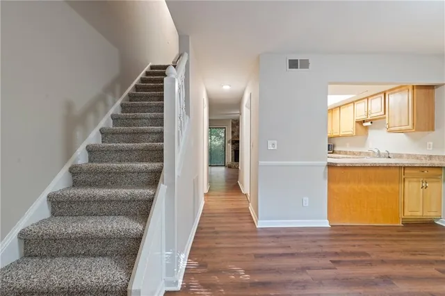a view of an entryway with wooden floor and a sink