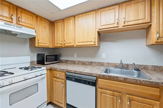 a kitchen with granite countertop cabinets stainless steel appliances and a sink