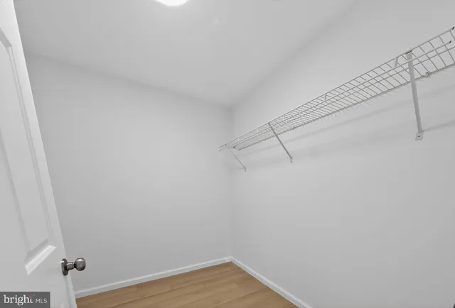 a view of small space with wooden floor and mirror