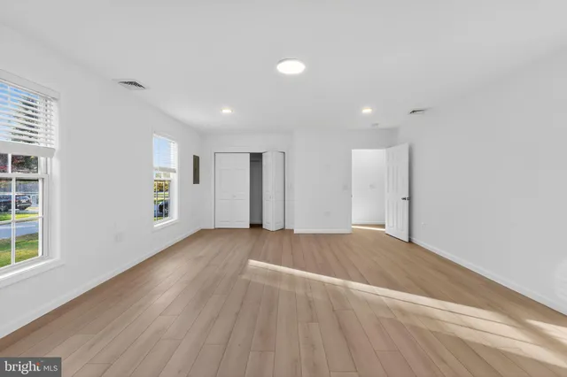 a view of a hallway with wooden floor and a window