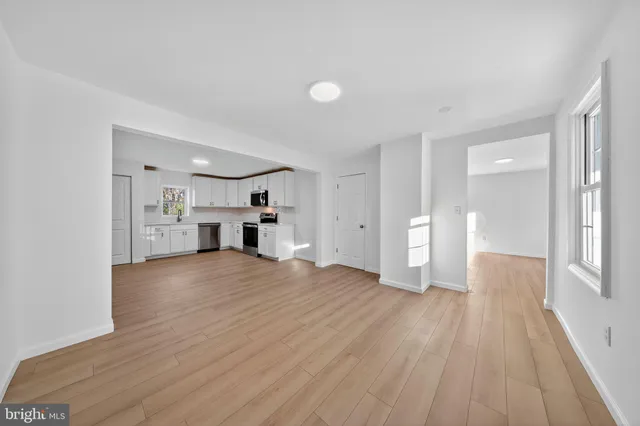 a kitchen with granite countertop a stove top oven a sink dishwasher and a refrigerator with wooden floor