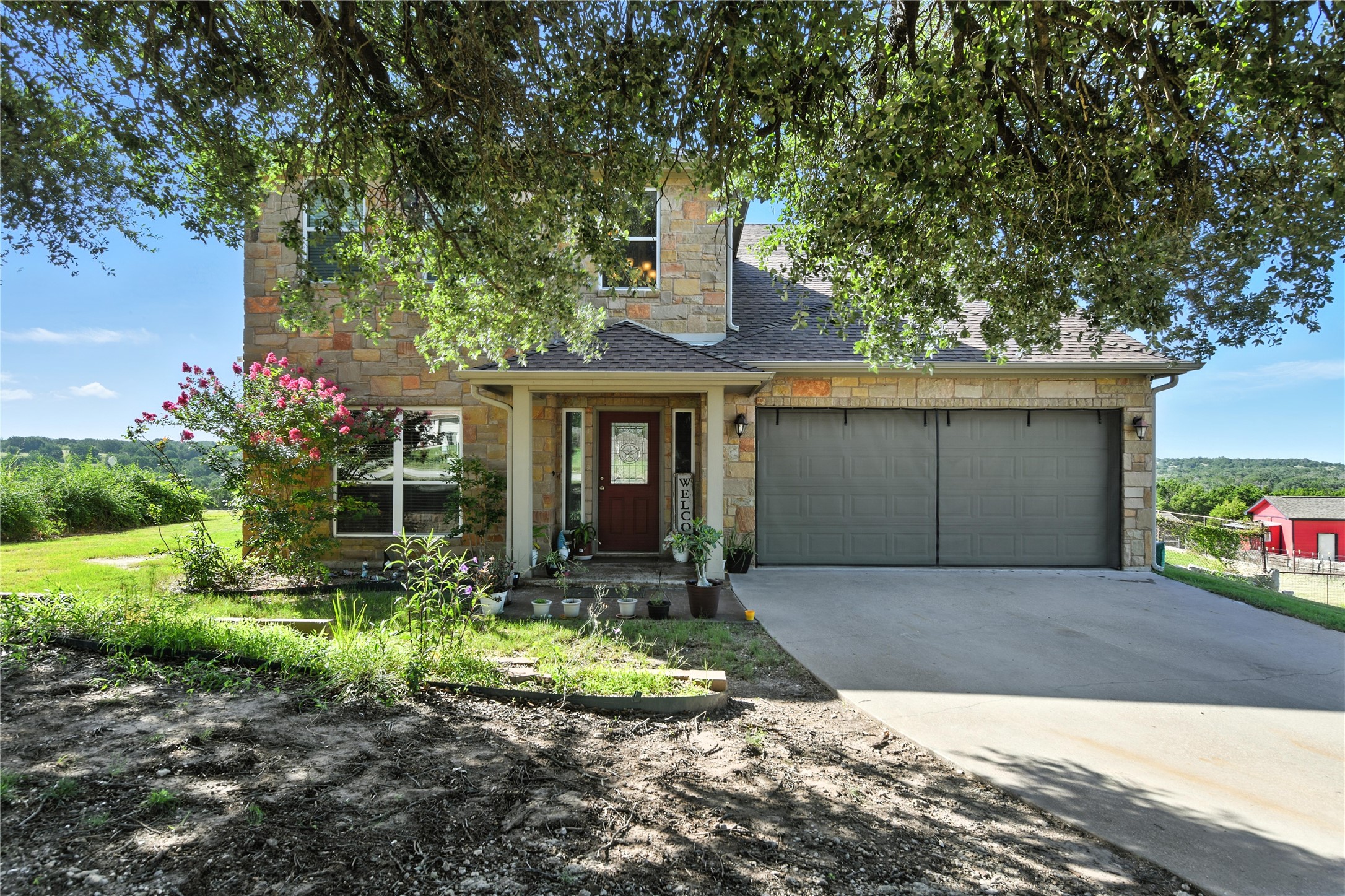 a front view of a house with a yard and potted plants