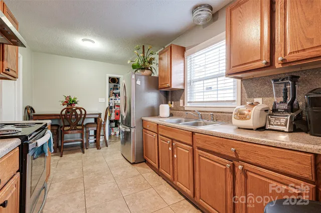 a kitchen with granite countertop cabinets a sink a window and stainless steel appliances