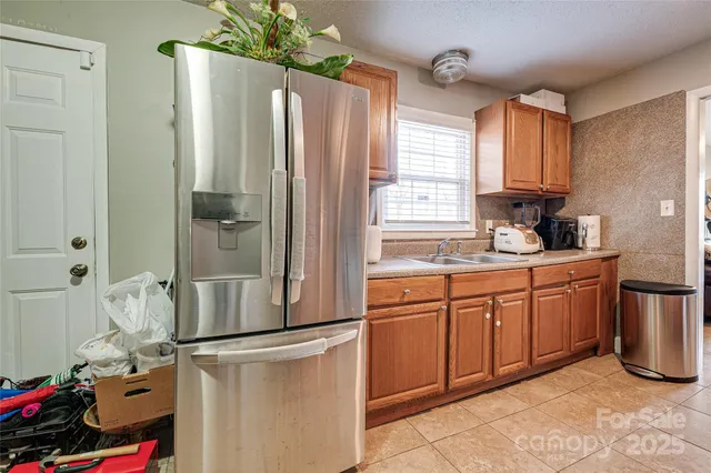 a kitchen with stainless steel appliances granite countertop a refrigerator and a sink