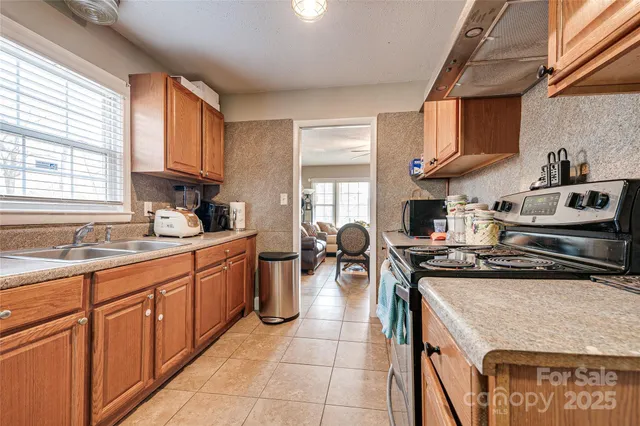 a kitchen with stainless steel appliances granite countertop a sink stove and cabinets