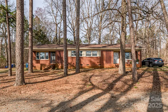 a view of a house with a large tree in the yard