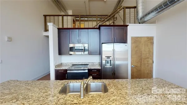 a kitchen with a refrigerator and a stove top oven