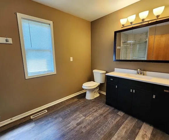 a bathroom with a toilet sink double vanity and mirror