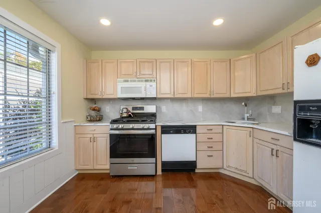 a kitchen with stainless steel appliances granite countertop a stove and white cabinets