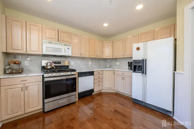 a kitchen with granite countertop white cabinets and white appliances
