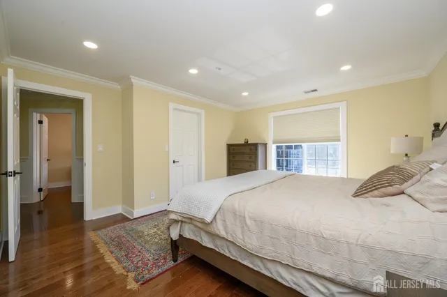 a bedroom with a large bed a wooden floor and closet