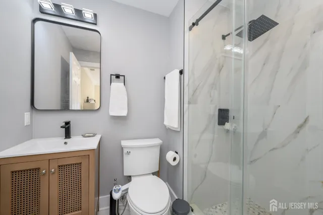 a bathroom with a toilet sink shower and mirror