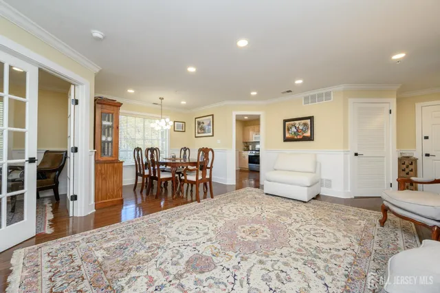 a living room with furniture and a dining table with wooden floor