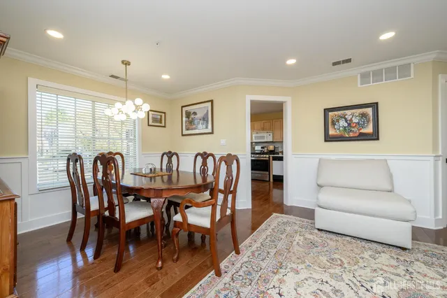 a view of a a dining room with furniture window and wooden floor