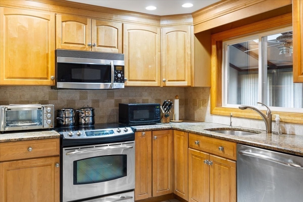 6 Sycamore Street Danvers, MA 01923 - Photo 11 of 30 a kitchen with stainless steel appliances granite countertop a stove a sink and a microwave