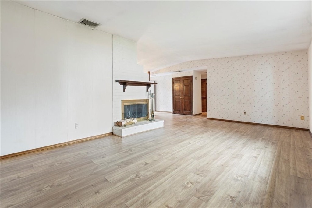 6 Sycamore Street Danvers, MA 01923 - Photo 5 of 30 a view of empty room with wooden floor and fireplace