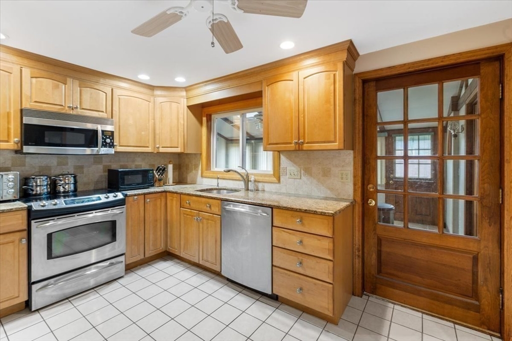 6 Sycamore Street Danvers, MA 01923 - Photo 9 of 30 a kitchen with stainless steel appliances granite countertop a stove sink and cabinets