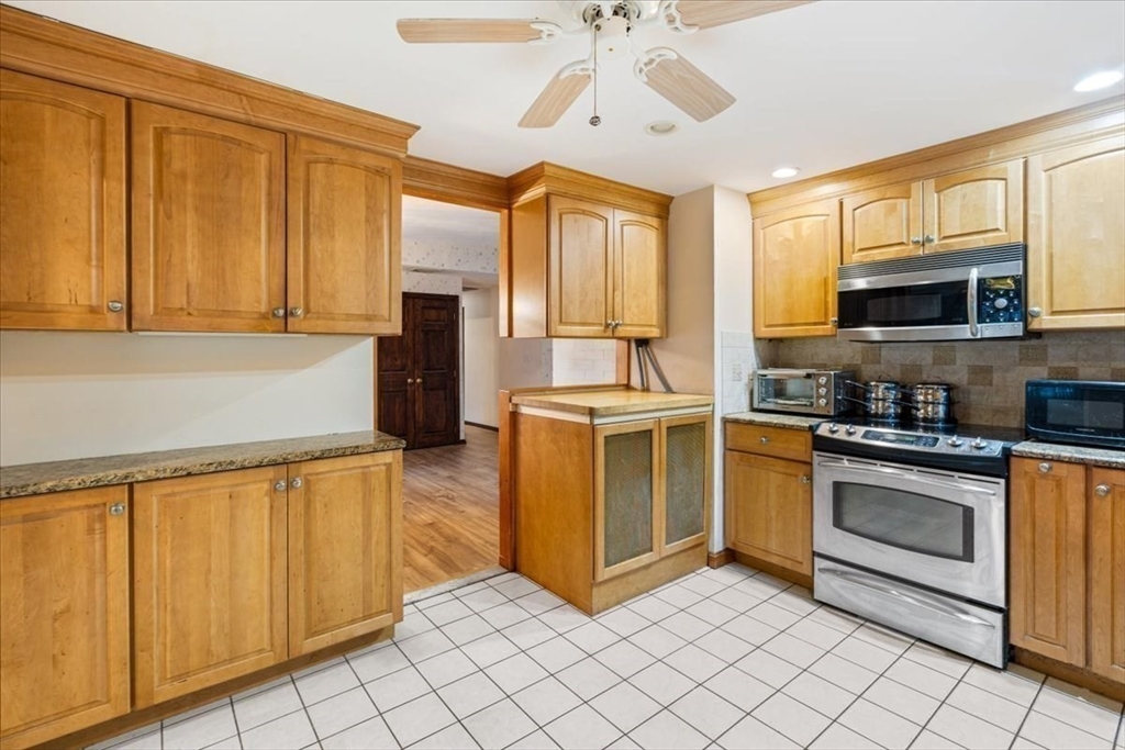 6 Sycamore Street Danvers, MA 01923 - Photo 10 of 30 a kitchen with stainless steel appliances granite countertop a stove a sink and a microwave