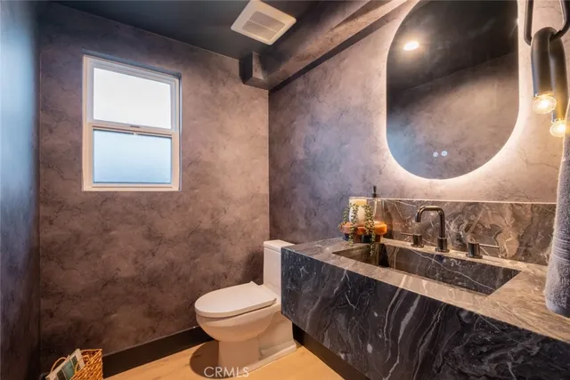 a bathroom with a toilet sink and mirror