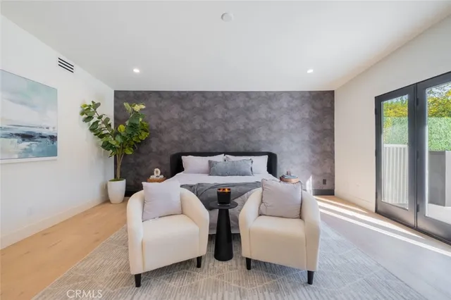 a spacious bedroom with a bed and a potted plant