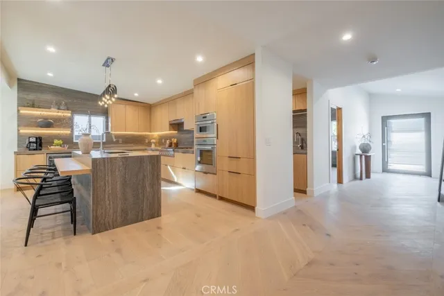 a kitchen with stainless steel appliances kitchen island granite countertop a refrigerator and a stove top oven