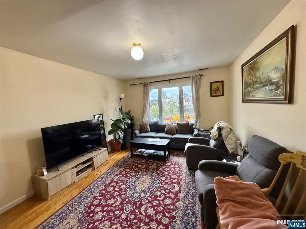 252 Passaic Avenue, Unit 2F East Newark, NJ 07029 - Photo 2 of 11 a living room with furniture and a flat screen tv