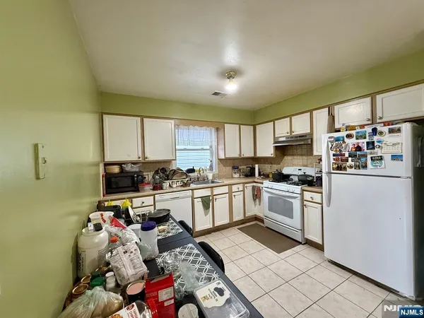 a kitchen with stainless steel appliances granite countertop a sink dishwasher stove top oven and cabinets