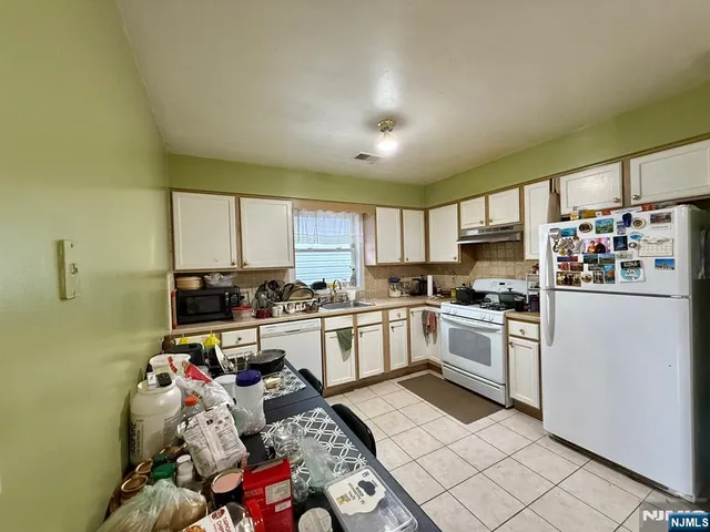 a kitchen with stainless steel appliances granite countertop a sink dishwasher stove top oven and cabinets