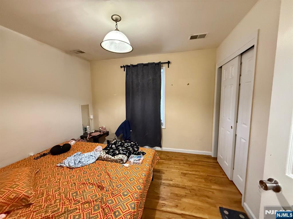 252 Passaic Avenue, Unit 2F East Newark, NJ 07029 - Photo 5 of 11 a bedroom with a bed and a chandelier