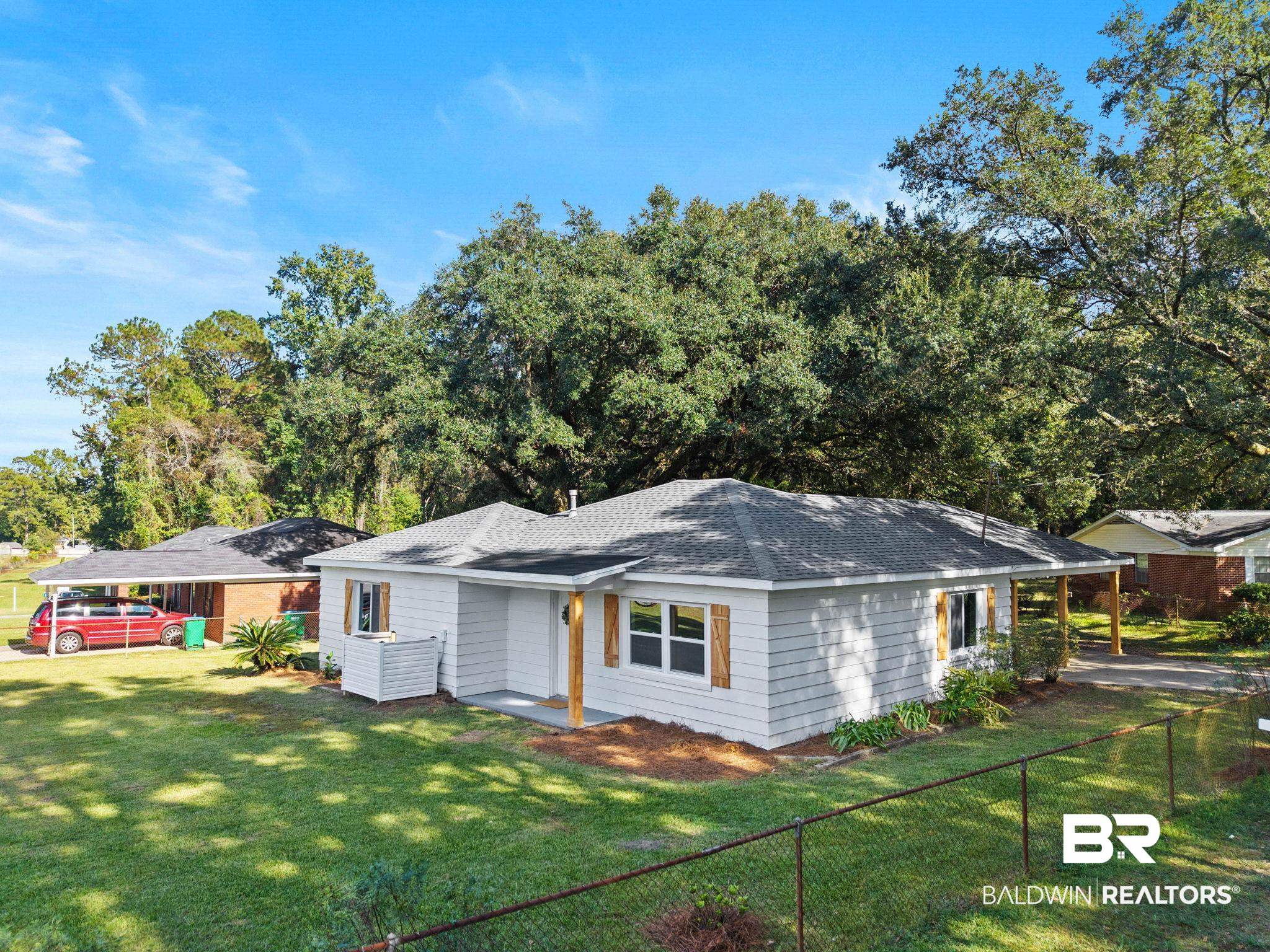 618 Pine Street Saraland, AL 36571 - Photo 6 of 41 View of front of home with a shingled roof and a fenced backyard