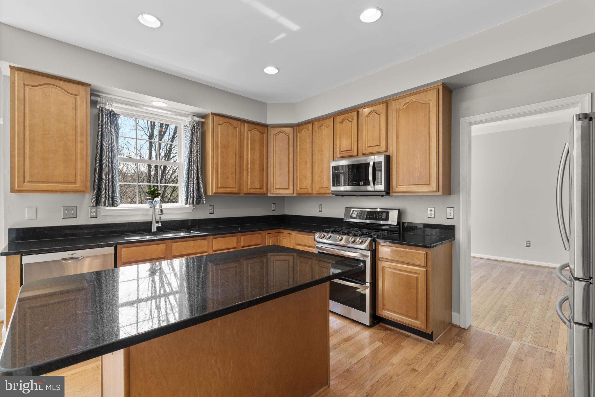 4520 Tulip Way Ellicott City, MD 21043 - Photo 3 of 63 a kitchen with stainless steel appliances granite countertop a stove a sink dishwasher a refrigerator and a microwave oven with wooden floor