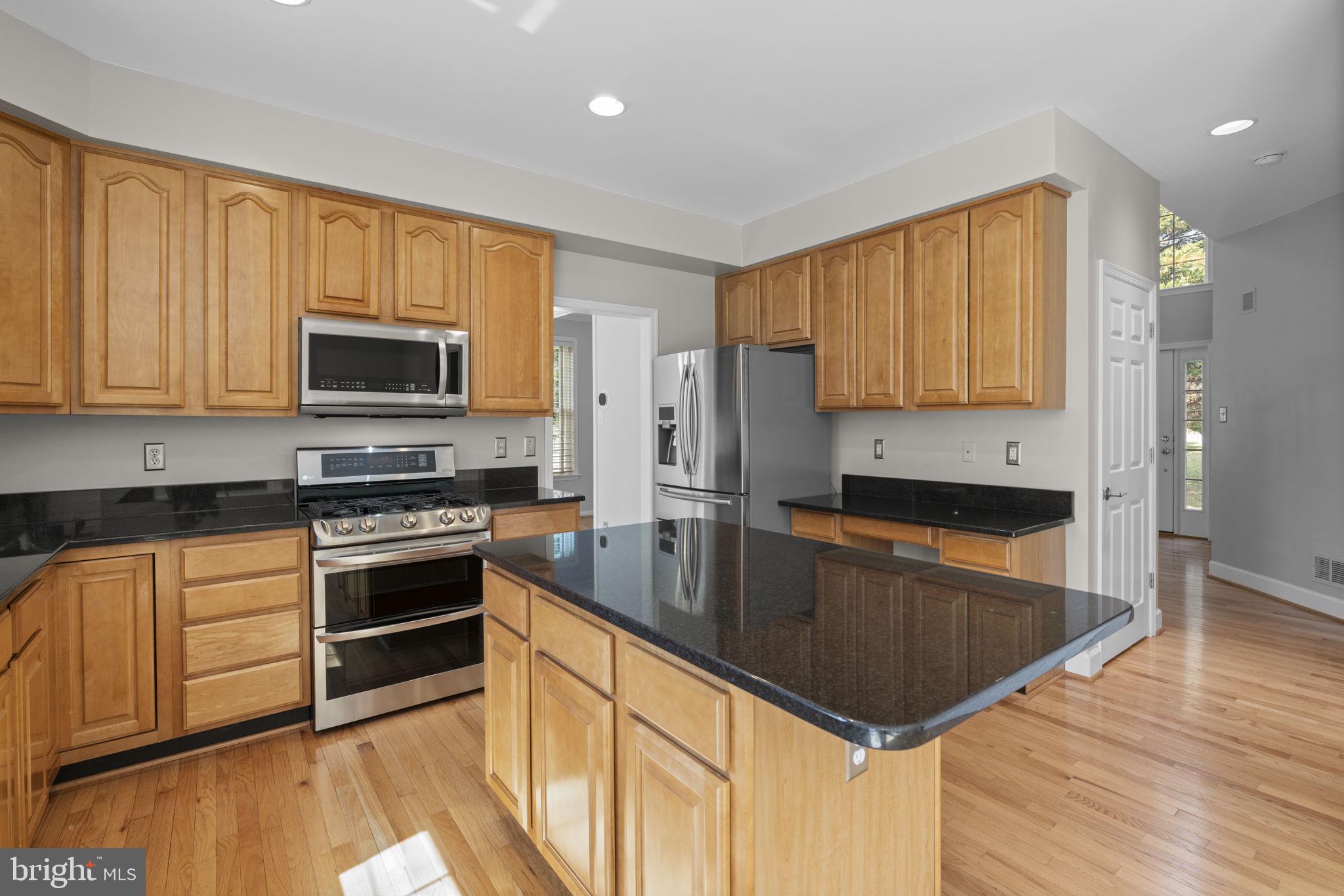 4520 Tulip Way Ellicott City, MD 21043 - Photo 4 of 63 a kitchen with stainless steel appliances granite countertop a stove a sink and a microwave