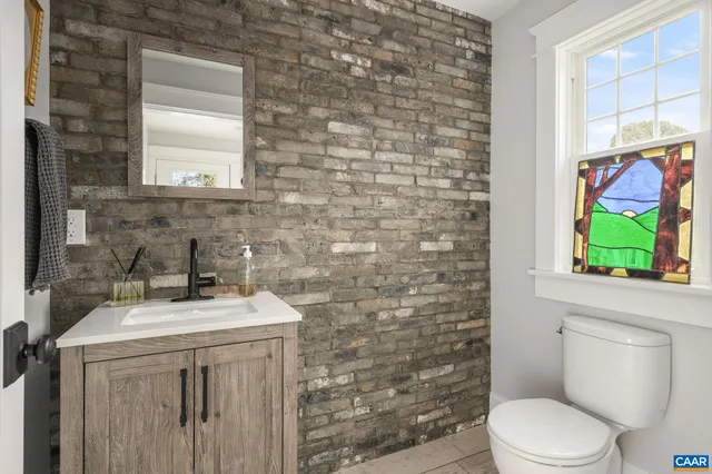 a bathroom with a sink a toilet and a window