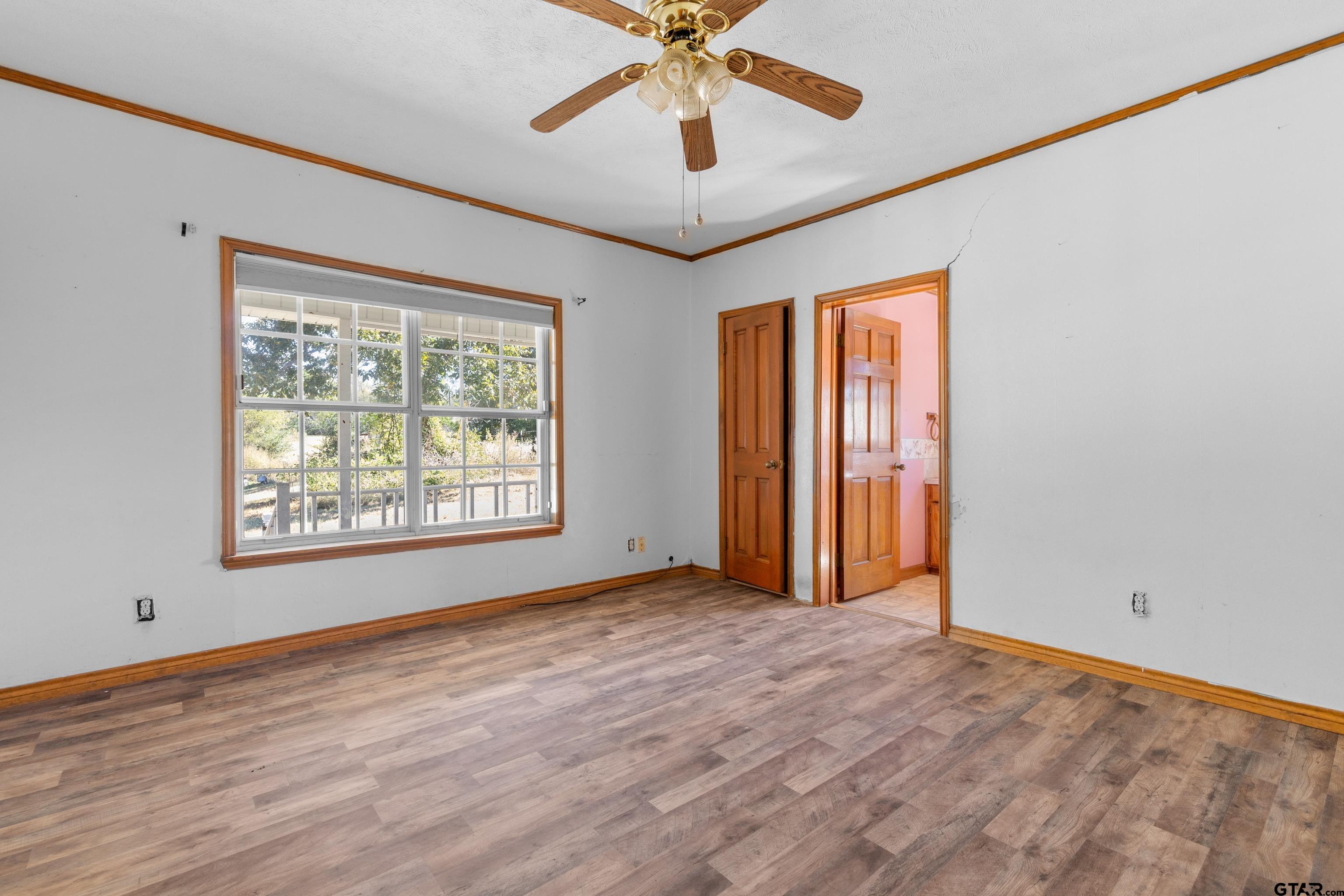 1159 County Road Mount Enterprise, TX 75681 - Photo 13 of 27 a view of an empty room with window and wooden floor