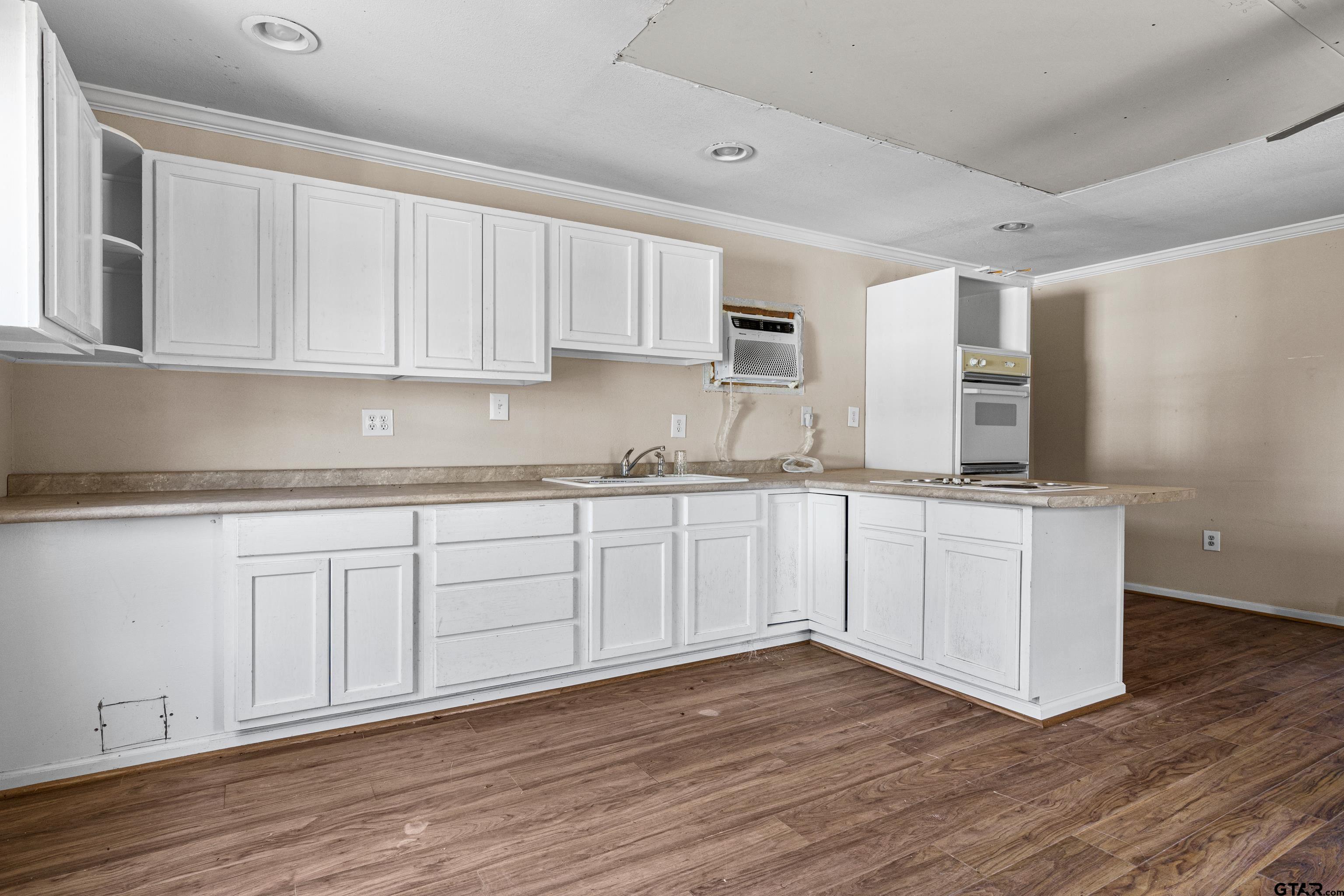 1159 County Road Mount Enterprise, TX 75681 - Photo 19 of 27 a kitchen with granite countertop white cabinets and white appliances