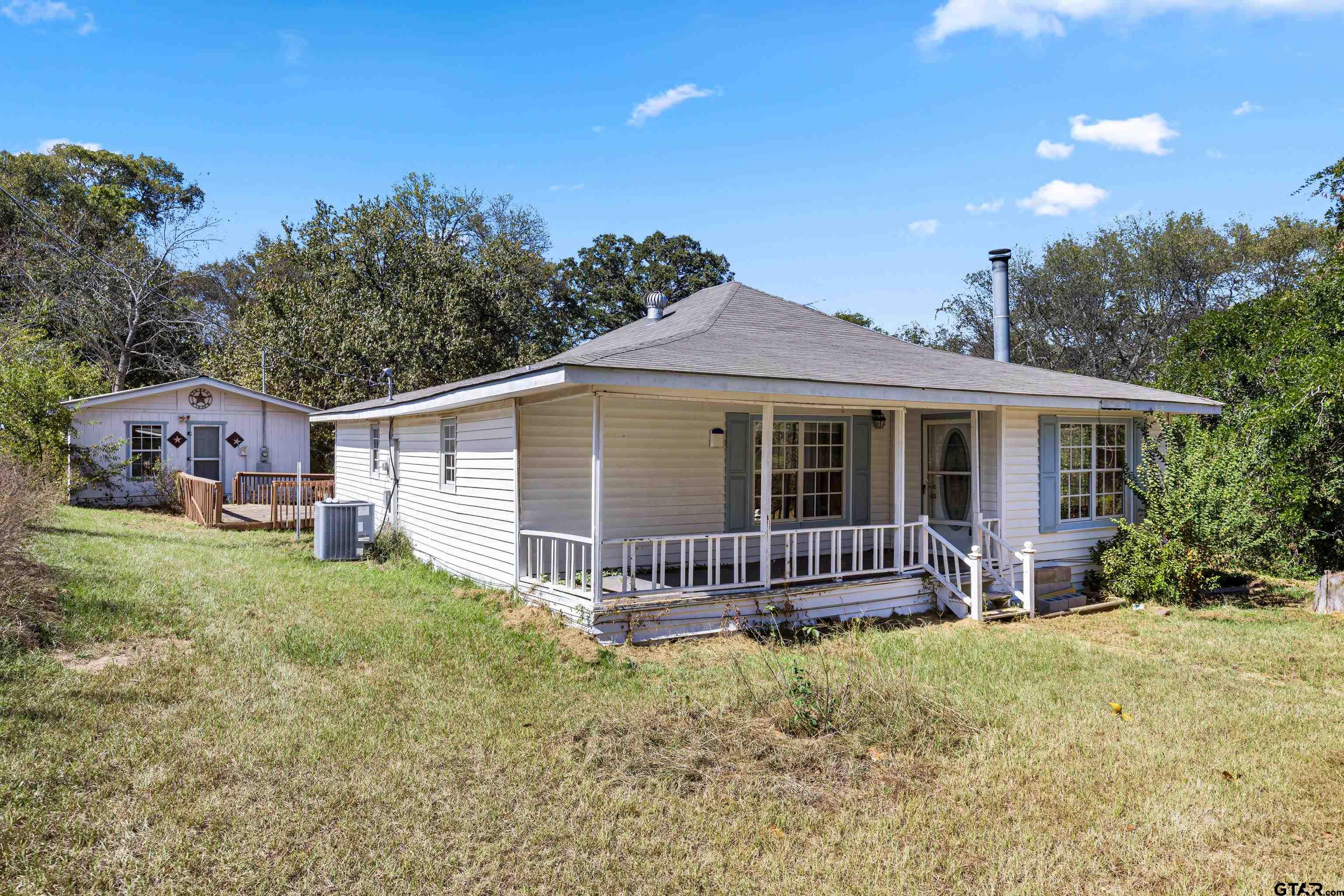 1159 County Road Mount Enterprise, TX 75681 - Photo 3 of 27 a front view of a house with a garden and porch