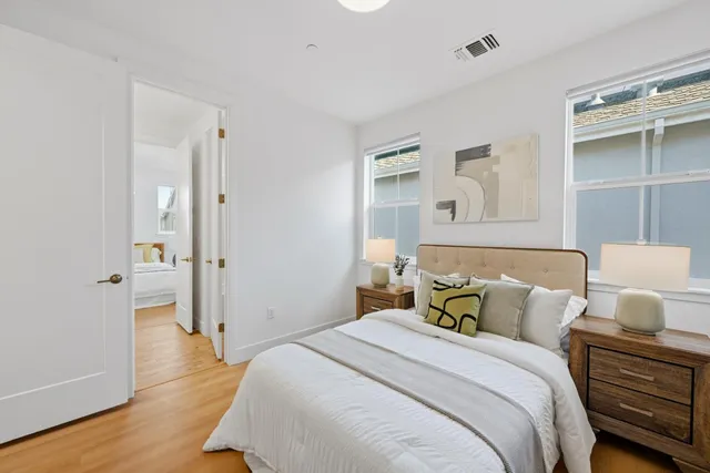 a bedroom with a bed and a flat tv screen on a table