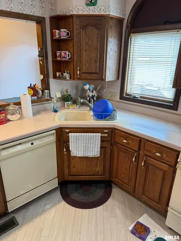 a kitchen with a sink cabinets and a wooden floor