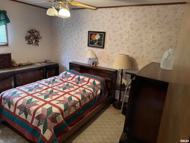 a bedroom with a bed and a lamp on dresser