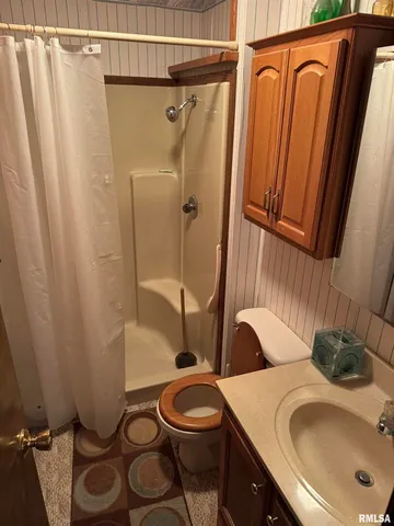 a bathroom with a sink a toilet and shower