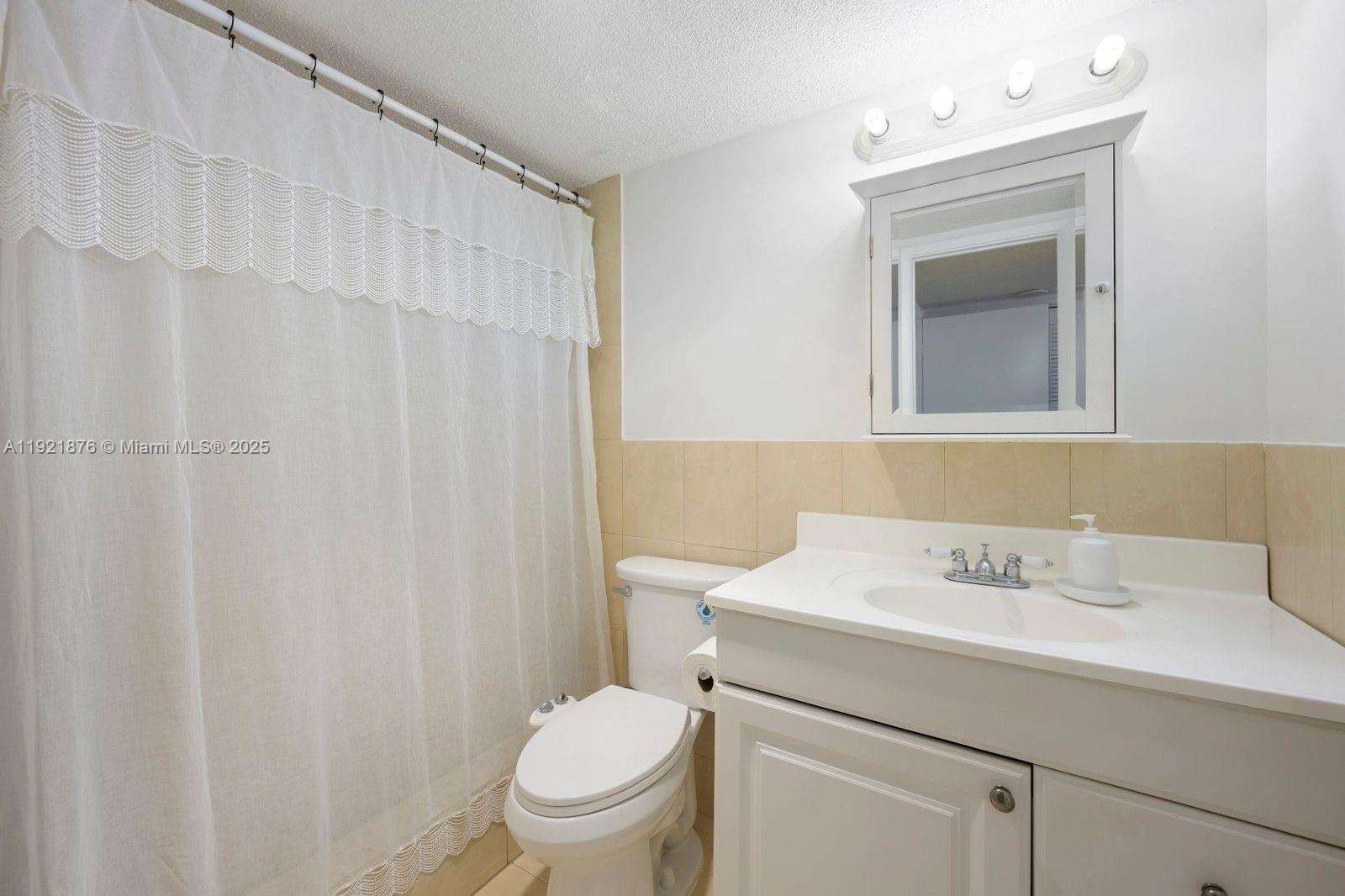 2851 Northeast 183rd Street, Unit 502E Aventura, FL 33160 - Photo 13 of 25 a bathroom with a sink a toilet and a mirror