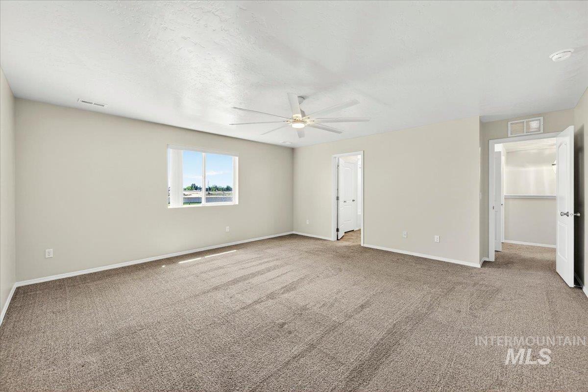 1555 Condor Drive Middleton, ID 83644 - Photo 41 of 50 Spacious carpeted room featuring a ceiling fan, a large window with horizontal blinds, and neutral painted walls
