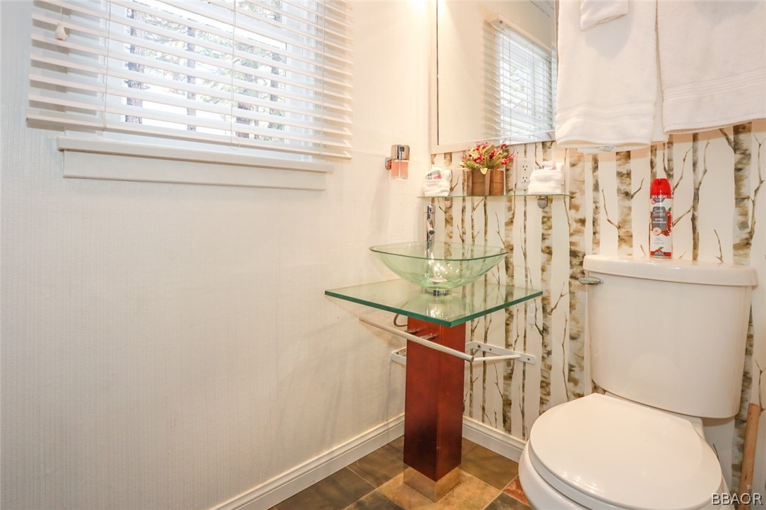 39016 1/2 Robin Road Big Bear Lake, CA 92315 - Photo 18 of 23 a bathroom with a toilet and a shower curtain