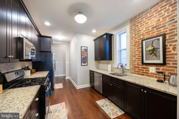 a kitchen with lots of counter top space a sink and stainless steel appliances